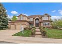Inviting brick two-story home with manicured lawn, mature trees, and three-car garage at 7914 S Clayton Cir, Centennial, CO 80122