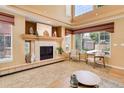 Comfortable living room with a fireplace and views of the surrounding neighborhood through expansive windows at 1446 Braewood Ave, Highlands Ranch, CO 80129