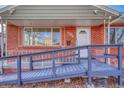 A welcoming front porch with access ramp leads to the front door of a classic brick home at 1051 Lima St, Aurora, CO 80010