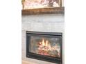 Close-up view of a cozy fireplace with a gray tile surround and decorative mantel at 9700 E 63Rd Pl, Denver, CO 80238