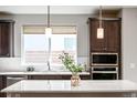 Modern kitchen featuring dark wood cabinets, stainless steel appliances, and a center island at 9700 E 63Rd Pl, Denver, CO 80238