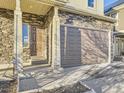 Detailed front entrance showcasing the stone facade, covered porch, and the two car garage at 18241 E 47Th Dr, Denver, CO 80249