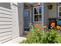 Charming entryway with a white door, flower garden, and bench, creating a welcoming entrance to the home at 9155 W Portland Ave, Littleton, CO 80128