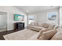 Spacious living room with L-shaped couch, fireplace, and sliding glass door to backyard at 507 Bonneville Ave, Fort Lupton, CO 80621