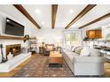 Inviting living room with exposed wood beams, fireplace, and comfortable seating arrangement at 10618 W Layton Pl, Littleton, CO 80127