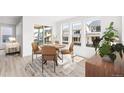 Bright dining area featuring a round wooden table, stylish chairs, and large windows with views of the backyard at 8864 Moonshimmer Trl, Littleton, CO 80125