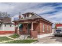 Quaint brick home featuring a covered front porch, landscaped garden, and classic architectural details at 2421 W 38Th Ave, Denver, CO 80211
