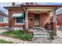 Inviting brick home entrance showcasing a charming porch, detailed door, and well-kept garden at 2421 W 38Th Ave, Denver, CO 80211