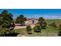 Inviting home with a welcoming porch surrounded by mature trees in a serene, natural setting at 29333 Rawhide Ct, Elizabeth, CO 80107