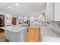 Spacious kitchen featuring white cabinets, stainless steel appliances, and a large center island at 4161 W Lake N Cir, Littleton, CO 80123