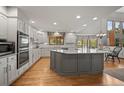 Bright, spacious kitchen featuring white cabinetry, stainless steel appliances, and a large center island at 4161 W Lake N Cir, Littleton, CO 80123