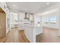 Modern kitchen featuring white cabinets, stainless steel appliances, a large island, and dining space at 8950 Whiteclover St, Littleton, CO 80125