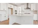 Elegant kitchen island with white cabinetry, stainless steel appliances, and tiled backsplash at 8950 Whiteclover St, Littleton, CO 80125