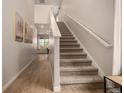 Bright interior featuring a carpeted staircase and light wood flooring leading to the upper level at 16432 Snowbourn Dr, Parker, CO 80134