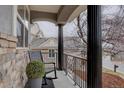 Inviting front porch with decorative columns, black metal railing, and a cozy rocking chair at 22921 E Euclid Cir, Aurora, CO 80016