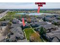 Aerial view of townhomes, green space, and Carpenter Park with a lake in the background under a partly cloudy sky at 3000 E 112 Ave # 102, Northglenn, CO 80233