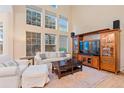 Bright living room with tall windows, comfortable seating, wooden floors, and entertainment center at 3000 E 112 Ave # 102, Northglenn, CO 80233