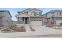 Charming two-story home featuring stone accents, gray siding, a two-car garage, and manicured landscaping at 8268 Mt Harvard Rd, Littleton, CO 80125