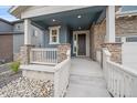 Close-up view of the home's porch that features stone column bases, a gray front door and a covered porch at 8268 Mt Harvard Rd, Littleton, CO 80125