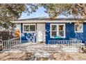 Close-up view of the blue house entrance with a welcoming porch, railing, and bright white trim at 1195 Florence St, Aurora, CO 80010
