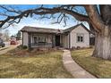 Inviting home exterior with manicured lawn, mature tree, and cozy front porch at 3200 S Logan St, Englewood, CO 80113