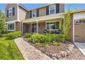 Inviting front porch features brick walkway, decorative landscaping, and seating area at 5988 E Jamison Ln, Centennial, CO 80112