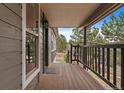 Cozy front porch featuring wood flooring, a welcome mat, and a view of the surrounding landscape at 8165 Tempest Ridge Way, Parker, CO 80134