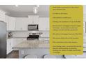 Modern kitchen boasts white cabinetry, stainless steel appliances, and a granite-topped island with seating at 21823 E 8Th Ave, Aurora, CO 80018