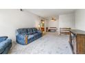 A bright living room with neutral carpet and a comfortable blue patterned sofa at 3550 S Harlan St # 214, Denver, CO 80235