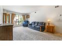 Inviting living room featuring a cozy seating arrangement and natural light through a large window at 3550 S Harlan St # 214, Denver, CO 80235