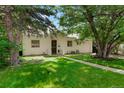 Charming home with a well-maintained front yard, mature trees, and inviting entrance with a lovely green lawn at 1070 S Newton St, Denver, CO 80219