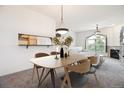 Open dining area features modern lighting and seamlessly connects to a living space and kitchen at 1878 S Cole St, Lakewood, CO 80228