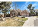 Brick home with well-maintained lawn, mature trees, and three-car garage at 10145 Joseph Dr, Highlands Ranch, CO 80130