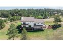 Expansive rear exterior view showcasing multiple decks and lush landscaping of the home at 10694 Camelot Dr, Franktown, CO 80116