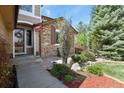 Charming front entrance with stone accents, a wreath, and manicured landscaping creating inviting curb appeal at 9536 W Avalon Dr, Littleton, CO 80127