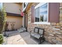 Welcoming front porch with stone accents, a bench, and manicured landscaping creating inviting curb appeal at 9536 W Avalon Dr, Littleton, CO 80127