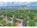 Stunning aerial view of home nestled in a lush neighborhood with the Rocky Mountains serving as a backdrop at 1607 Ulysses St, Golden, CO 80401