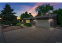 The beautiful one-story home is displayed at dusk, featuring a brick facade and well-maintained landscaping at 1607 Ulysses St, Golden, CO 80401