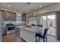 Modern kitchen featuring granite countertops, stainless steel appliances, island and barstool seating at 17910 E 54Th Ave, Denver, CO 80249