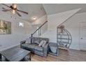 Inviting living room featuring a comfortable sofa, stylish decor, staircase, and wood look flooring at 17910 E 54Th Ave, Denver, CO 80249