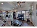 Cozy living room with wood-look flooring, ceiling fan and large windows filling the room with light at 17910 E 54Th Ave, Denver, CO 80249