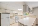 Traditional-style kitchen with a full set of appliances, light cabinets and a peninsula at 360 Upham St, Lakewood, CO 80226