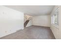 Bright living room featuring neutral carpet and stairs leading to the upper level at 360 Upham St, Lakewood, CO 80226