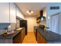 Open kitchen with sleek countertops and wood cabinets, tile backsplash and modern appliances at 3100 S Federal Blvd # 307, Denver, CO 80236
