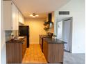 Functional kitchen featuring wood cabinets, tile backsplash and modern appliances at 3100 S Federal Blvd # 307, Denver, CO 80236