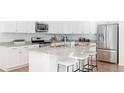 Modern kitchen with stainless steel appliances, a central island with seating, and ample cabinet space at 17850 W 94Th Dr, Arvada, CO 80007