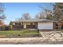 Inviting single-story brick home with an attached two-car garage and a well-kept front yard at 798 Xenophon St, Lakewood, CO 80401