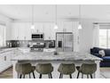 Bright, all-white kitchen featuring a spacious island with granite countertops and modern stainless steel appliances at 2023 S Upham Way, Denver, CO 80227