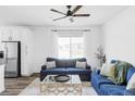 Inviting living room with bright natural light, neutral-toned walls, and comfortable blue couches at 2023 S Upham Way, Denver, CO 80227
