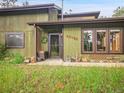 View of home's front porch showing updated windows, front door, and well-manicured lawn at 26765 Bradley St, Conifer, CO 80433